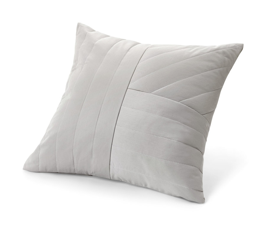 Béžový dekorativní polštář s geometrickým prošíváním.