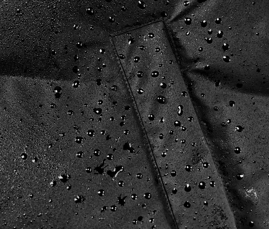 Detail zimního kabátu do deště s kapkami vody.