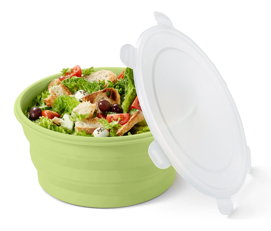 Zelená skládací salátová mísa s obsahem a bílým víkem vedle ní.