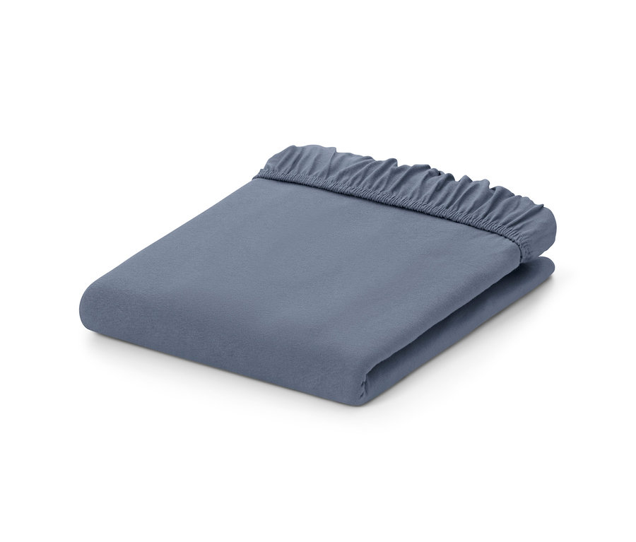 Složené modré žerzejové prostěradlo s gumou.