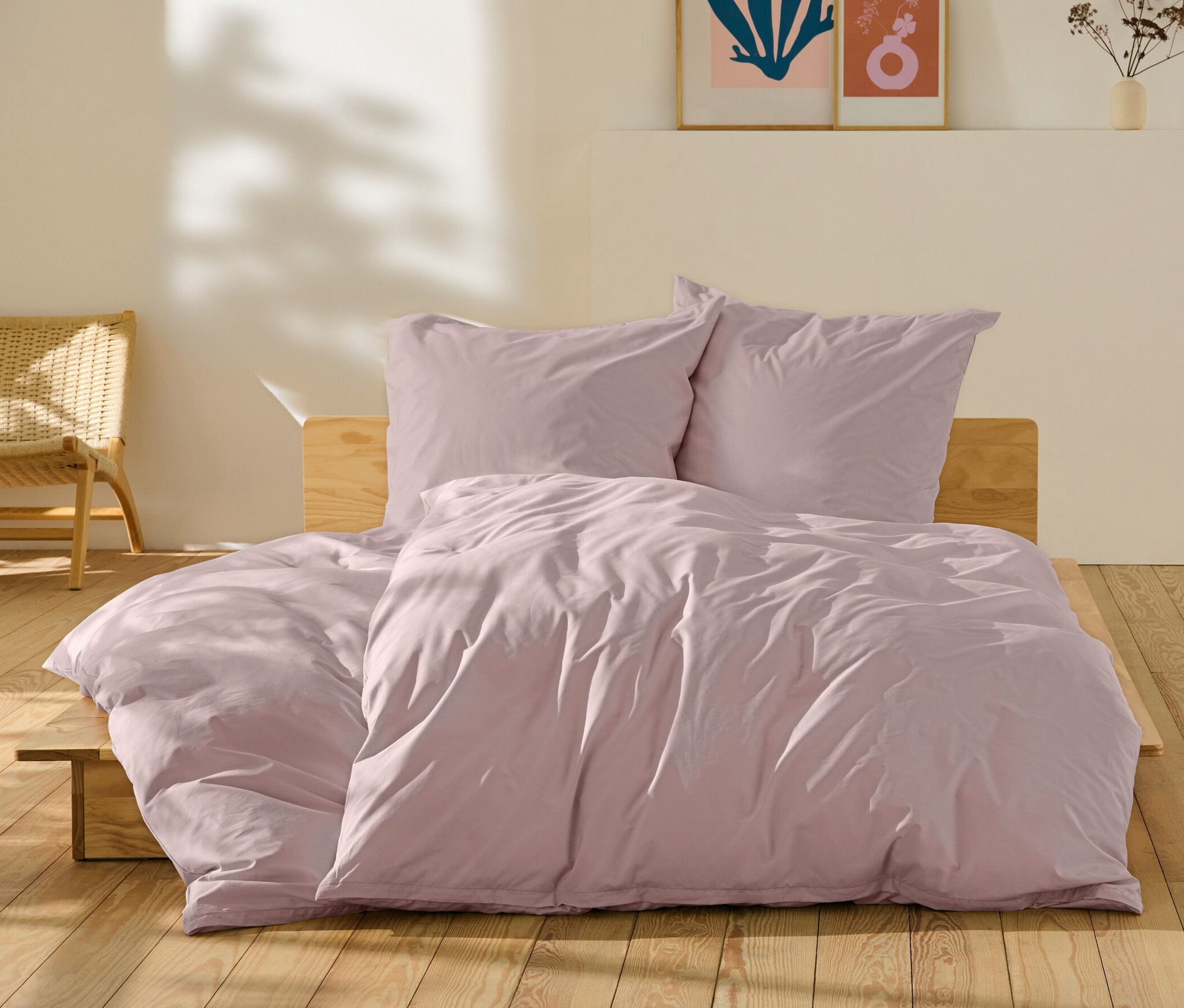 Růžové perkálové povlečení standardní a nadměrné velikosti na posteli.