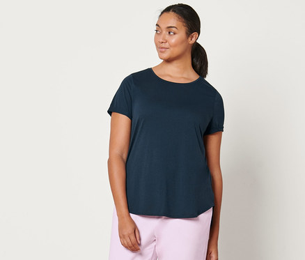 Žena má na sobě světle růžové teplákové kalhoty a tmavě modré dlouhé triko.