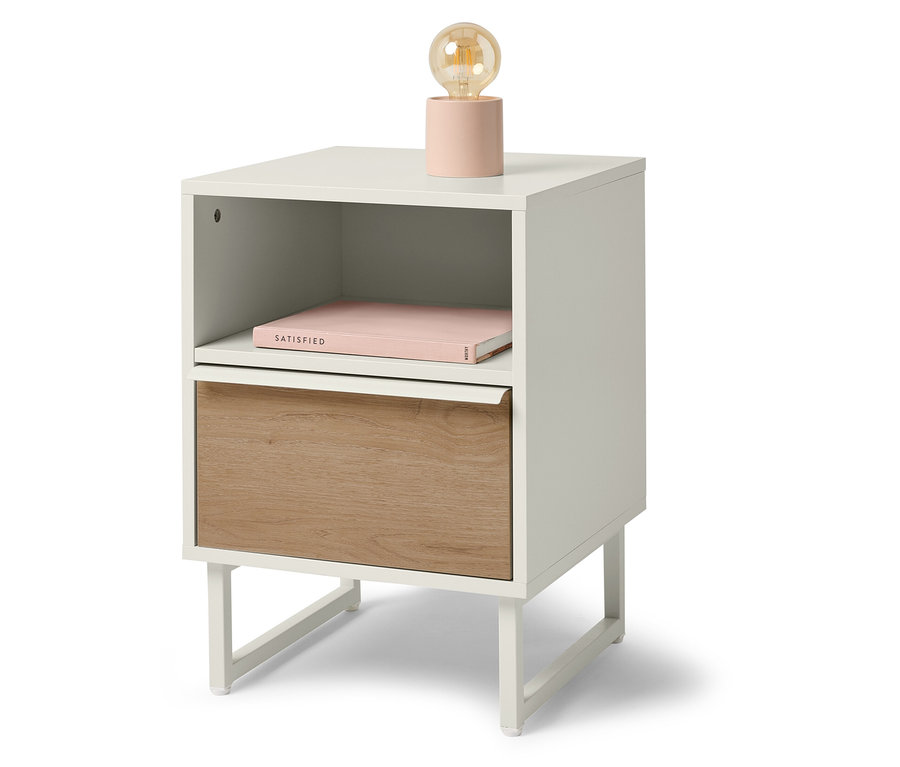 Bílý noční stolek s dřevěnou zásuvkou, knihou a lampou.