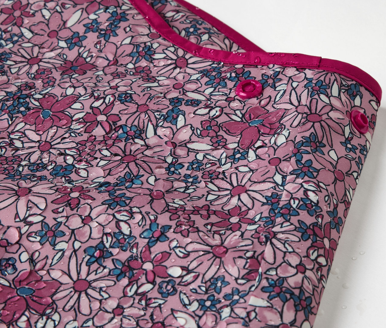 Detail dětských termo kalhot do deště s květinovým vzorem.