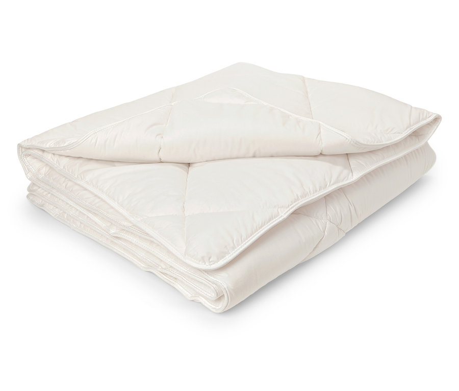 Složená bílá prošívaná přikrývka.