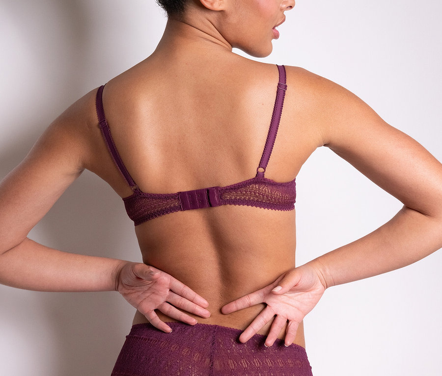 Žena zády k fotoaparátu má na sobě fialovou krajkovou podprsenku Passionata »Leila« a odpovídající kalhotky.