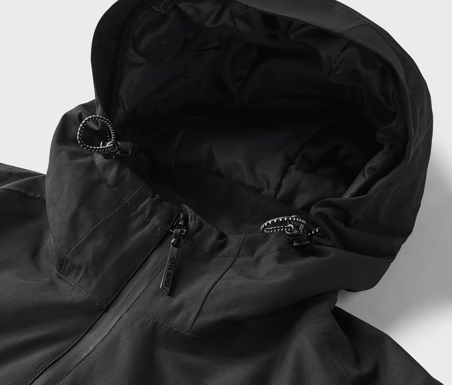 Detail černé bundy s kapucí a stahovacími šňůrkami.