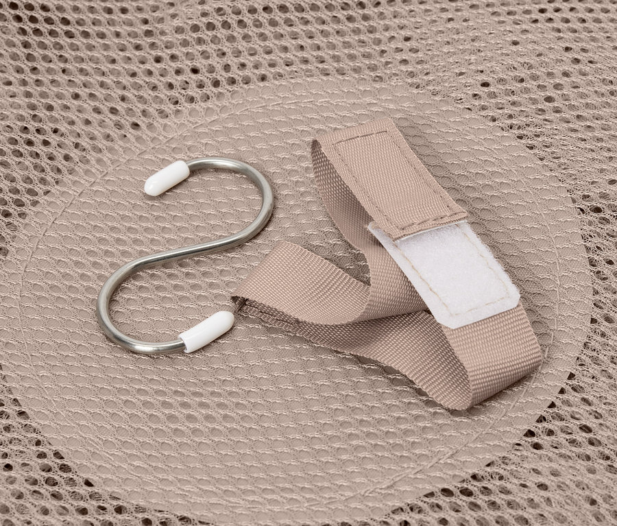 Hák a popruh leží na béžové úložné síti.