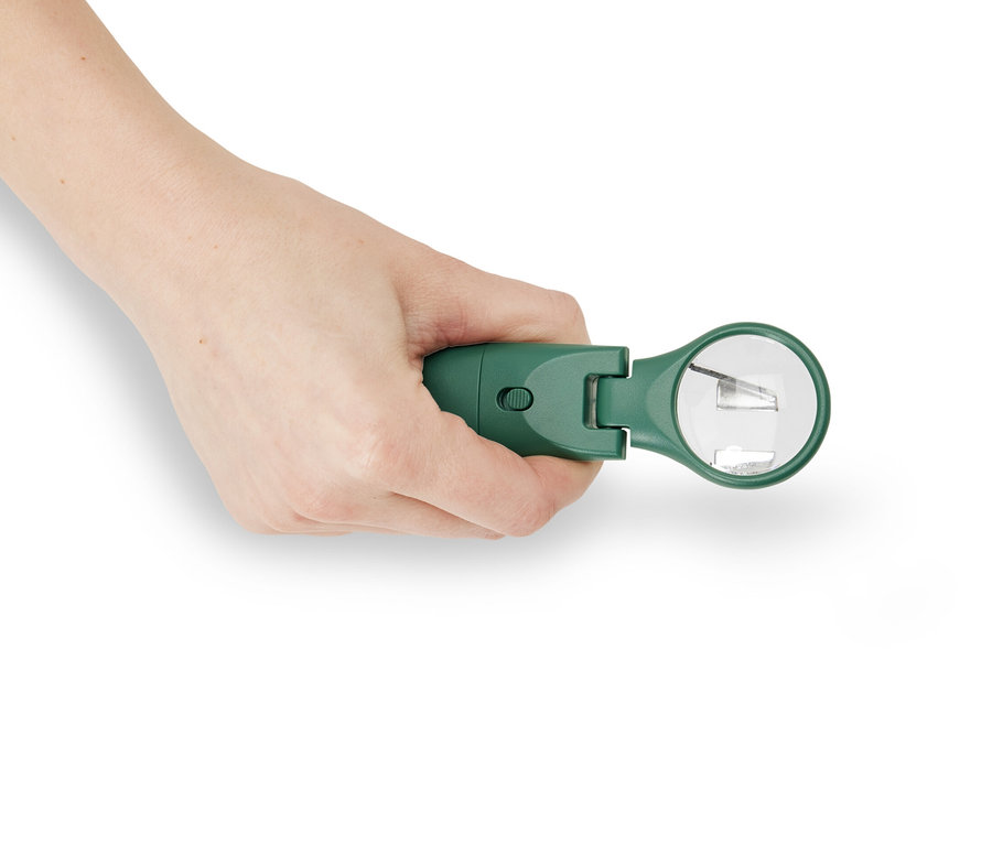 Ruka drží zelený nástroj na odstraňování klíšťat s LED světlem.