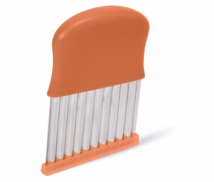 Detailní záběr na oranžový kráječ zeleniny se zvlněnými čepelemi.