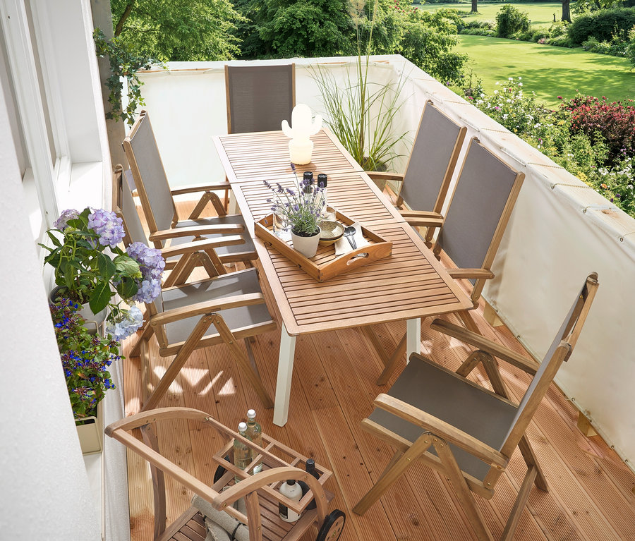 Na balkóně je úzký rozkládací zahradní stůl »Liska«, krémová balkónová zástěna a ochrana proti větru, barový vozík s odnímatelným podnosem a LED venkovní dobíjecí stolní lampa, kaktus.