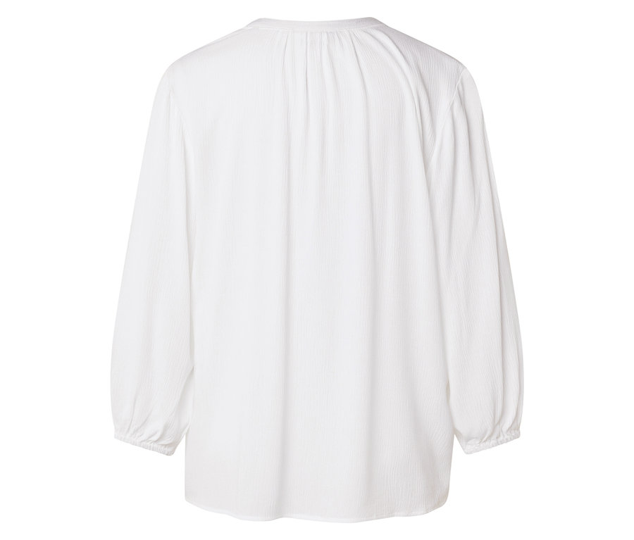 Pohled zezadu na bílou blůzu s dlouhým rukávem.