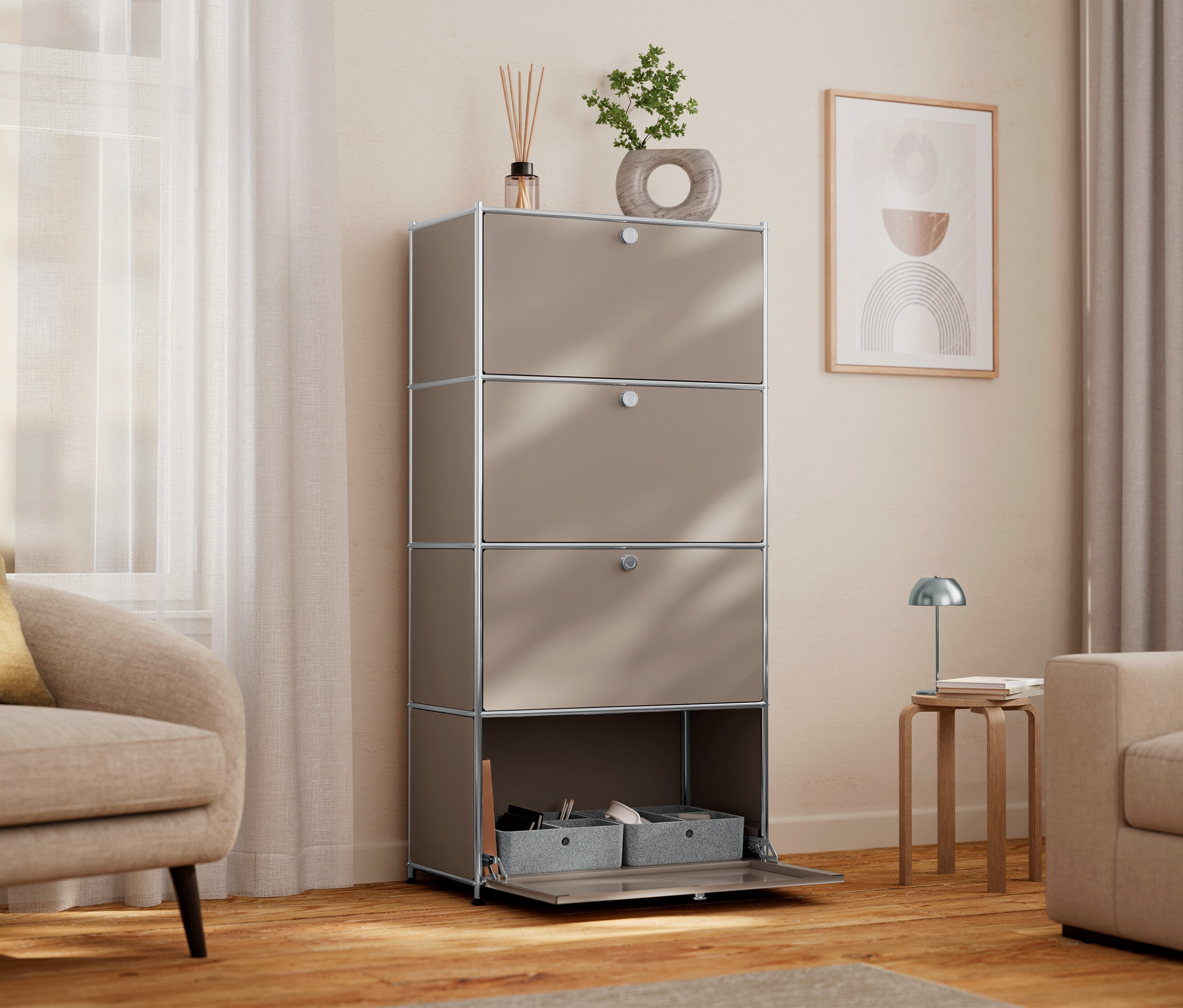 Interiérová scéna zobrazuje vysokou béžovou skříňku se čtyřmi přihrádkami, z nichž jedna je otevřená a zobrazuje šedé úložné boxy. Na skříňce je umístěna pokojová rostlina a vonné tyčinky.