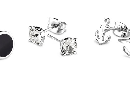 Sada náušnic: černé kruhové náušnice, čiré náušnice a náušnice ve tvaru kotvy.