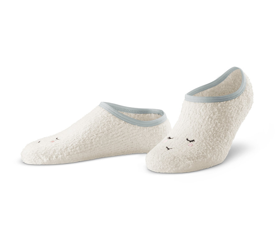 Dva páry bílých ponožkových papučí s našitým obličejem.