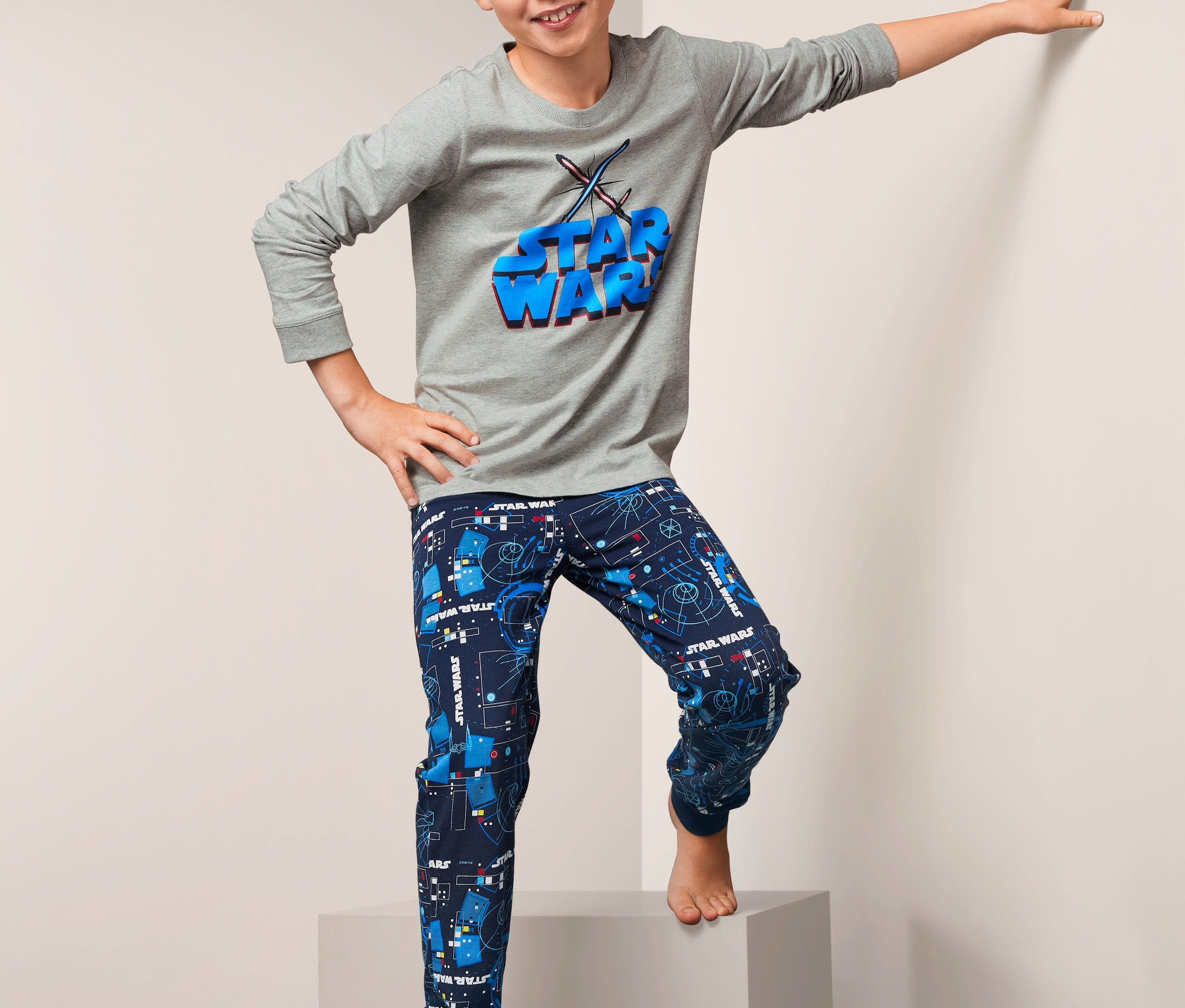 Chlapec pózuje na schodech v pyžamu „Star Wars“.
