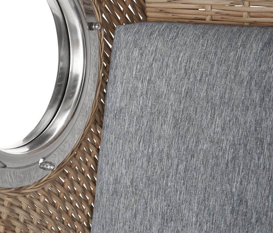Detail prémiového plážového koše XXL s 2 sklápěcími stolky, ukazující proutěný exteriér, kulaté okno a šedou látkovou podložku.