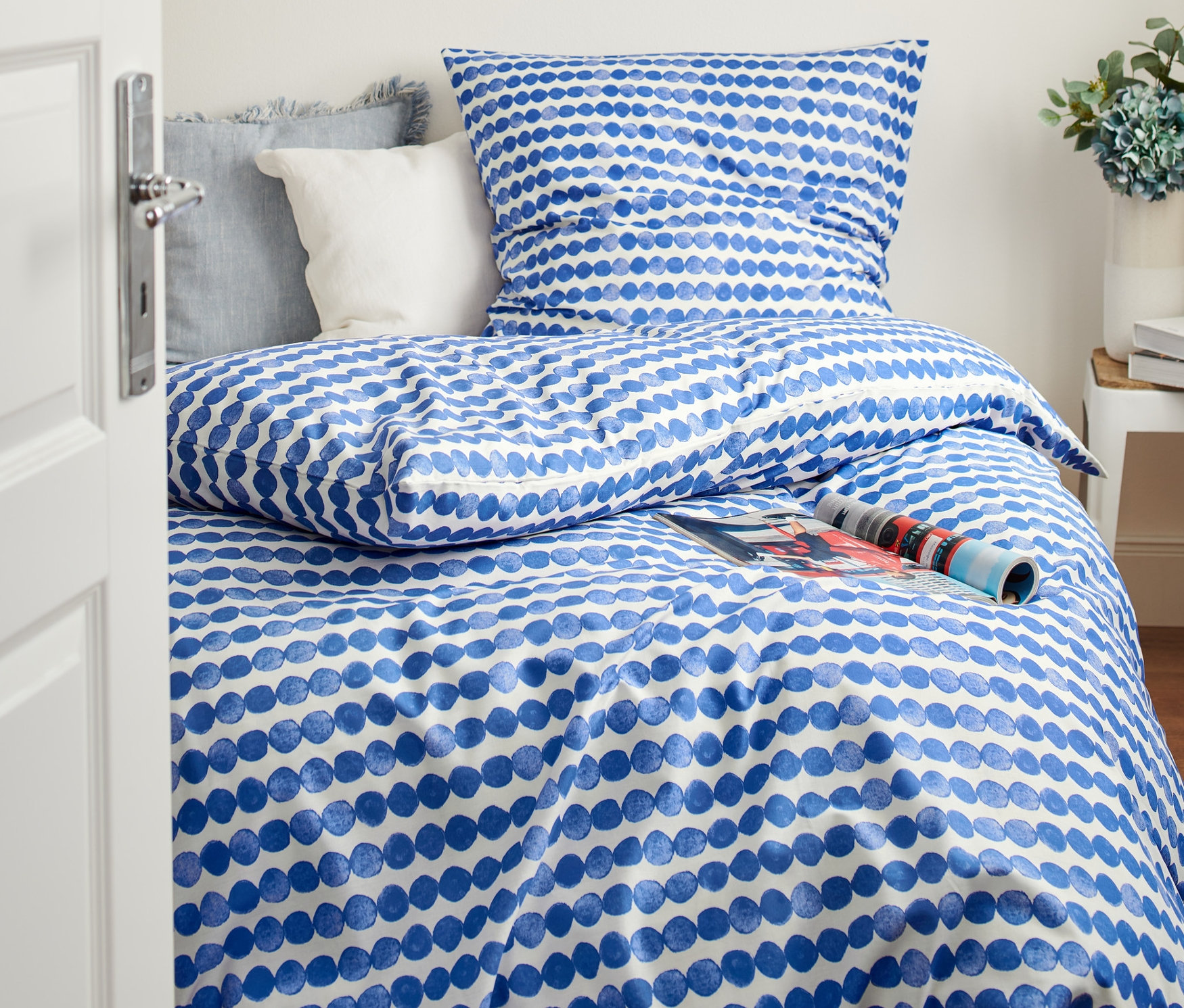 Ložnice s postelí s prémiovým bavlněným povlečením s modrým vzorem, velikosti pro dvoulůžko a standardní velikosti.