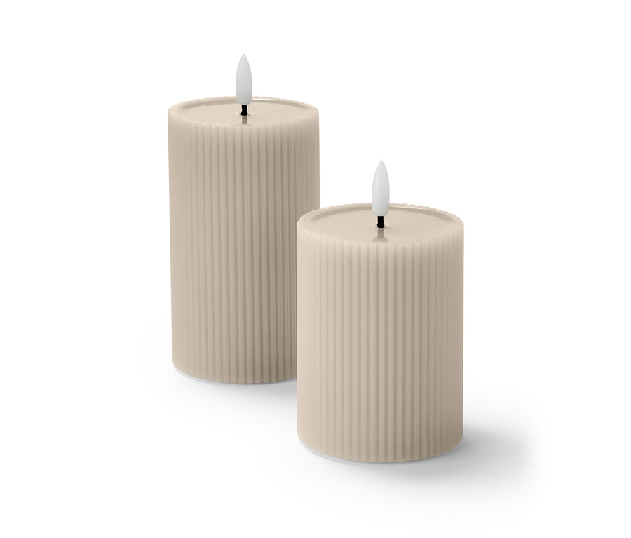 Dvě LED svíčky z pravého vosku, béžové barvy, s vroubkovaným povrchem, stojí vedle sebe.