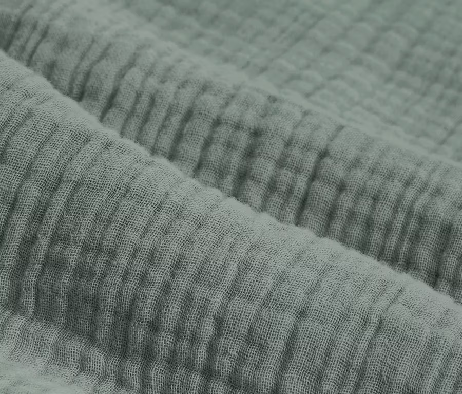 Detailní záběr na zelené mušelínové povlečení standardní a nadměrné velikosti.