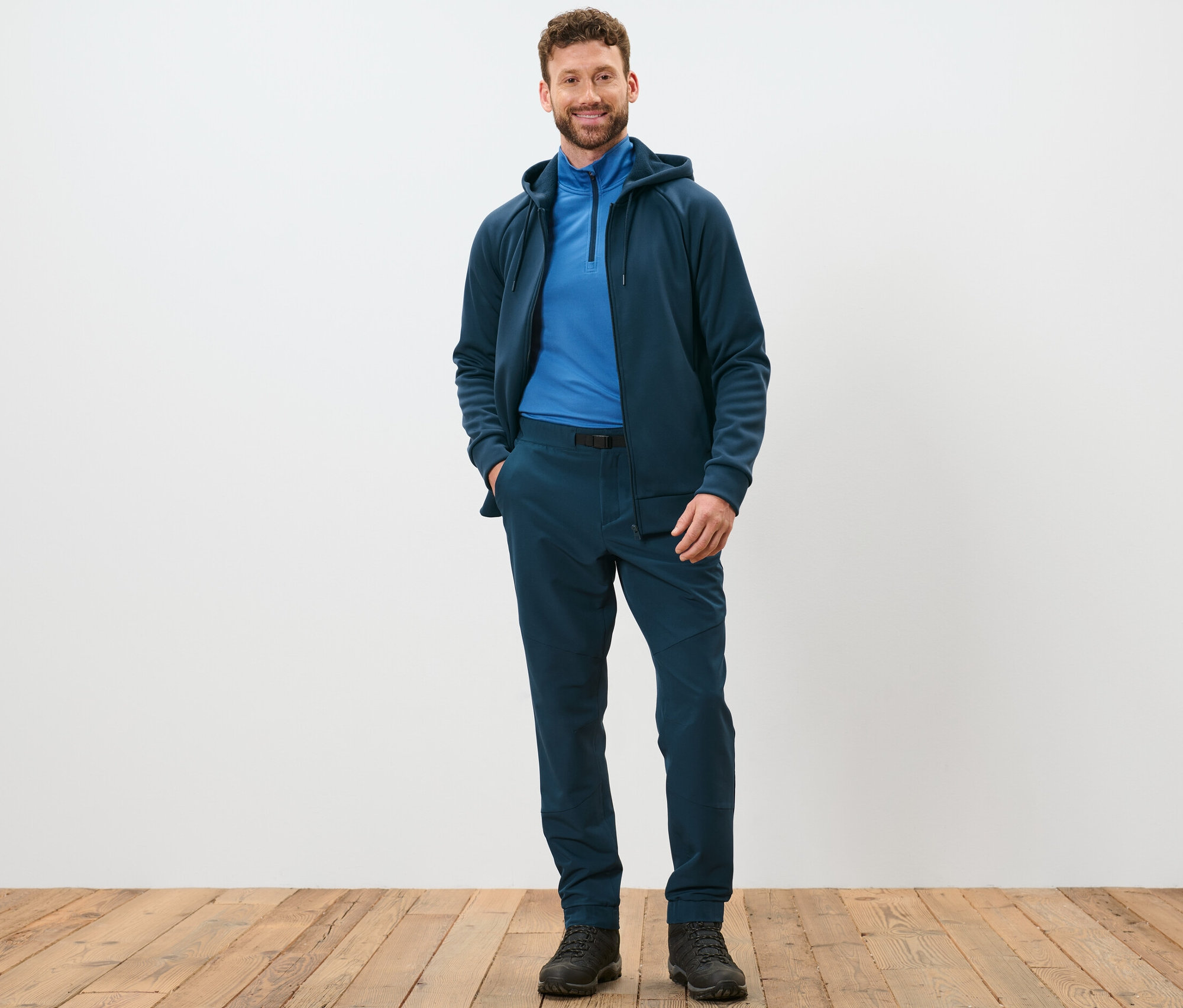 Muž stojí a pózuje v termokalhotách s opaskem.