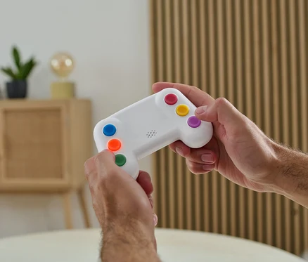 Muž drží v rukou elektronický trenažér paměti s barevnými tlačítky.