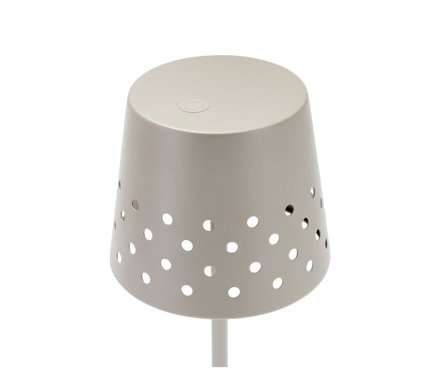 Detail kovové stojací LED lampy. Bezdrátová lampa má na sobě kruhové otvory.
