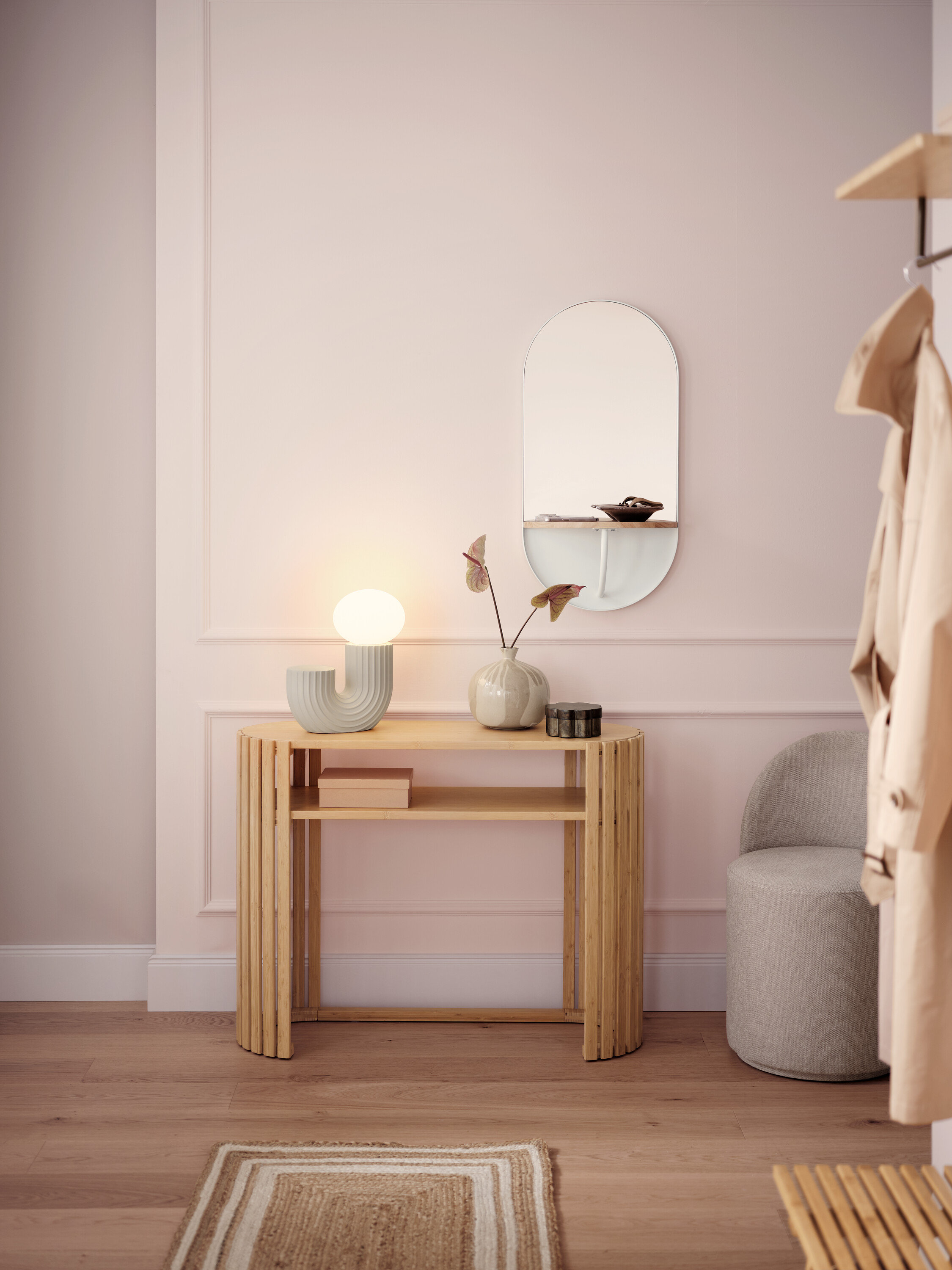 Světlá chodba s dřevěným konzolovým stolkem, lampou, zrcadlem a šedou stoličkou.