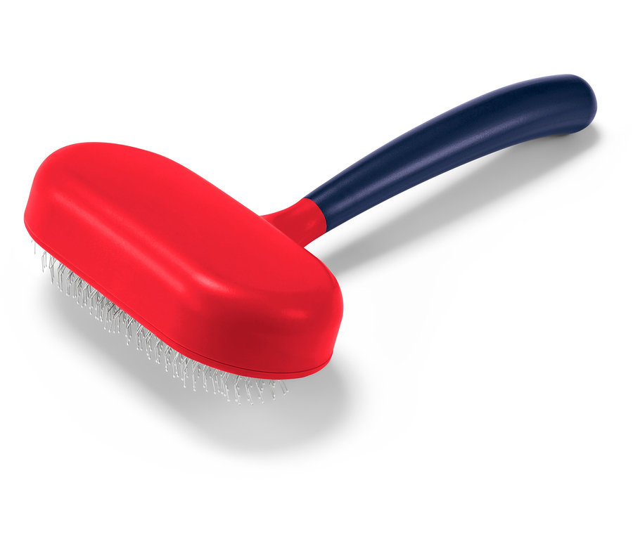 Červený kartáč na zvířata s modrou rukojetí leží na bílém pozadí.
