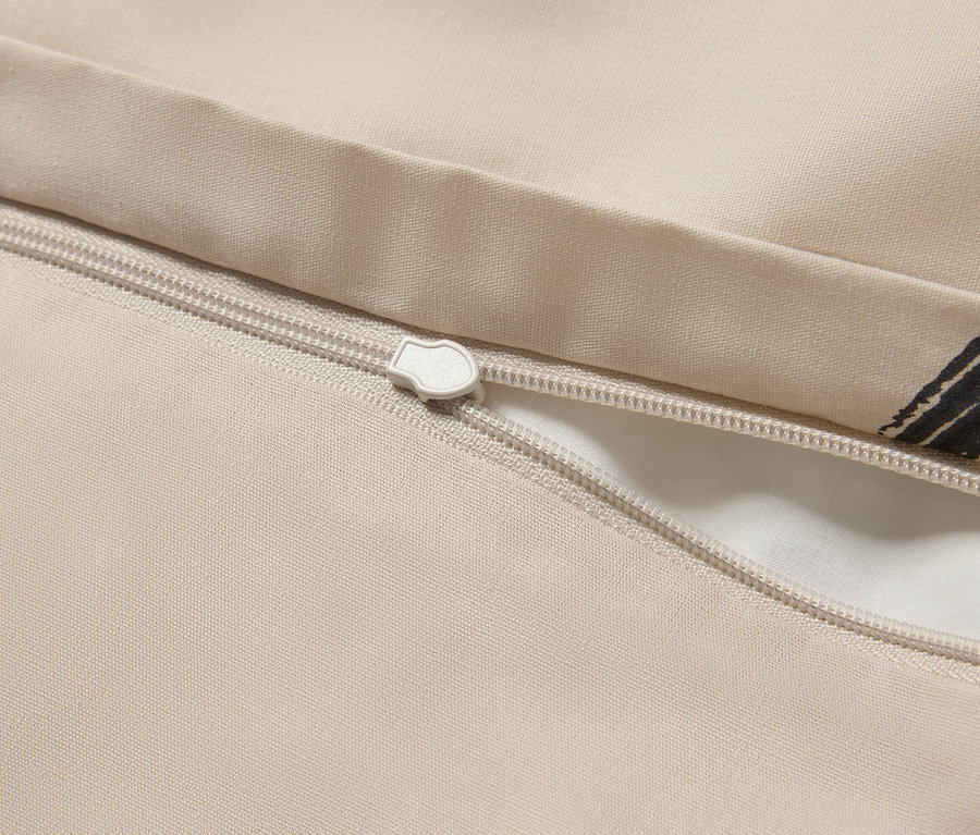 Detail béžového povlečení se zipem.