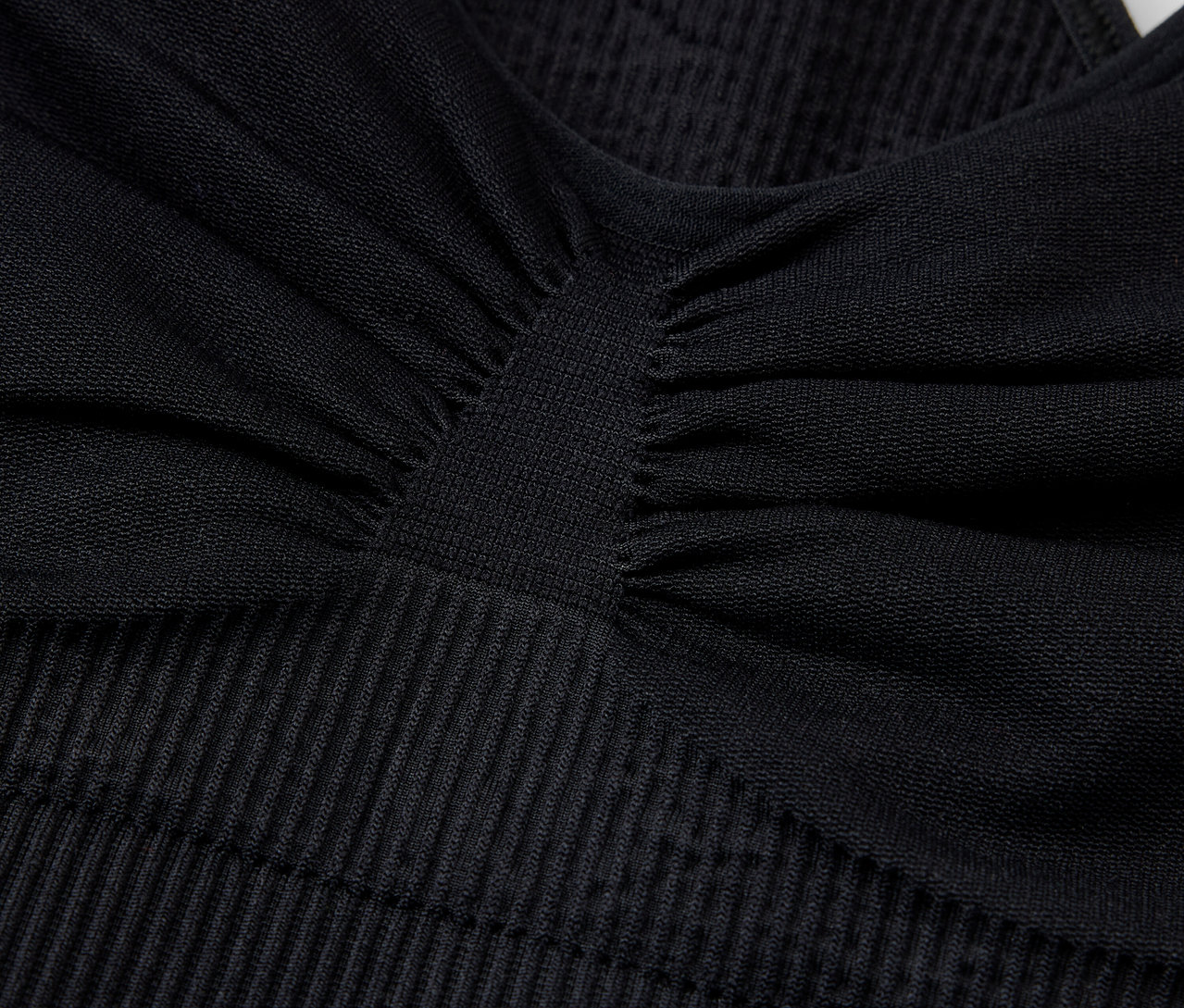 Detailní záběr na černou sportovní podprsenku s texturou.