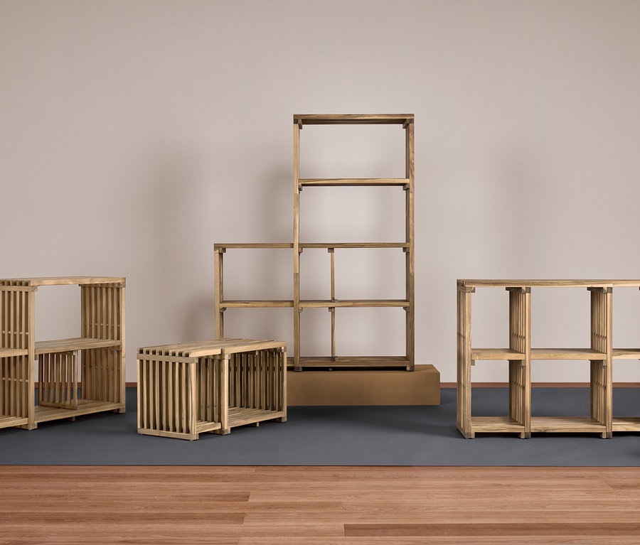 Čtyři dřevěné regály různých velikostí na šedé podložce na dřevěné podlaze.