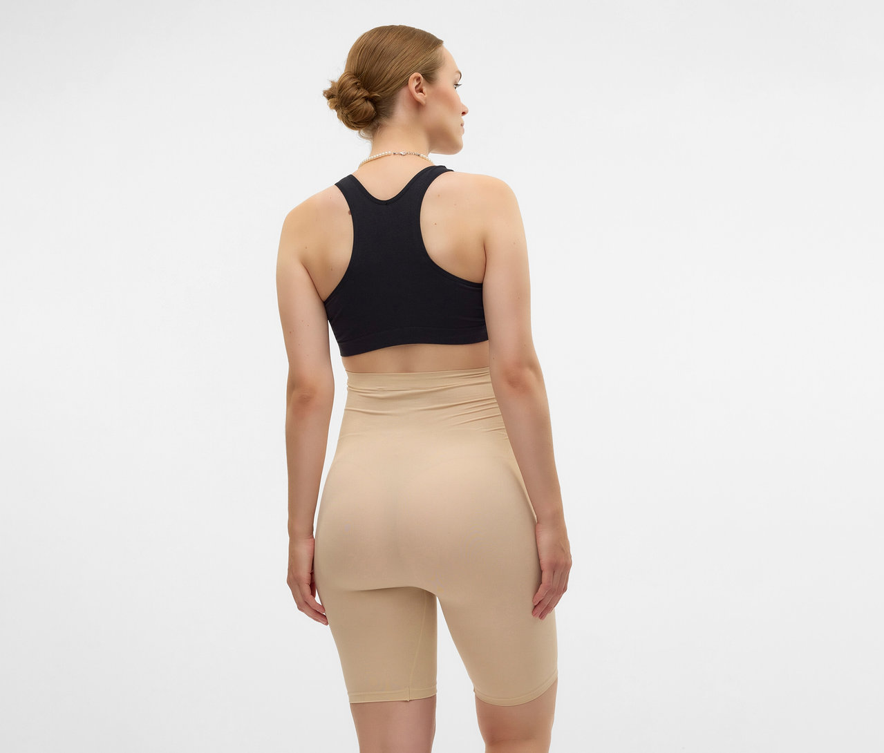 Žena zezadu v černé sportovní podprsence a černých skinny šortkách MAMALICIOUS »MLTIA JEANNE«.