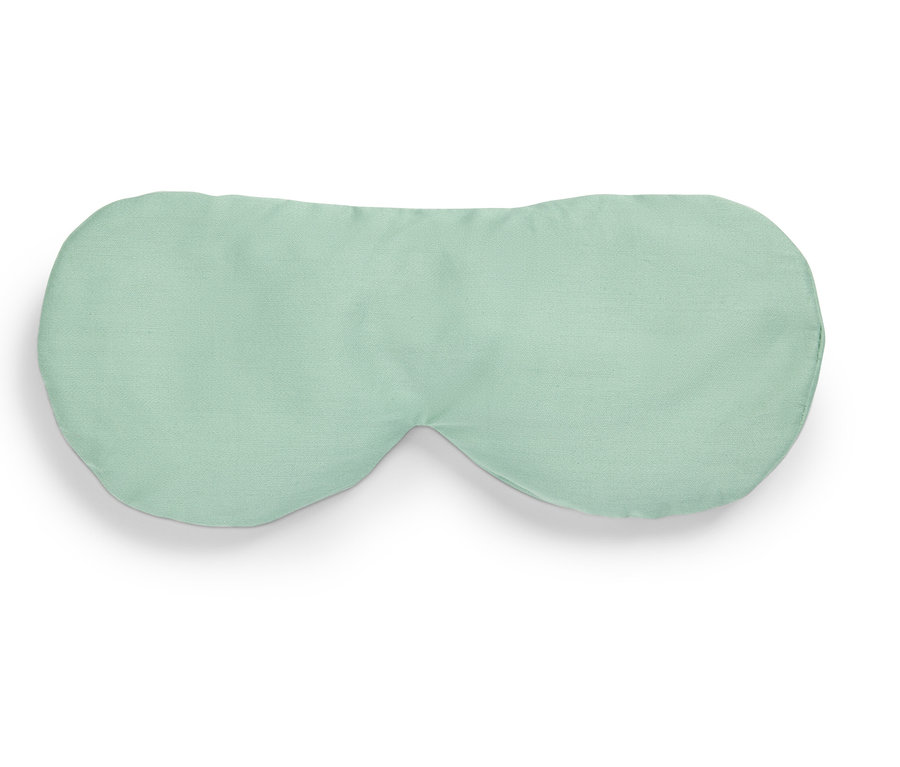 Světle zelená maska na spaní leží na bílém pozadí.