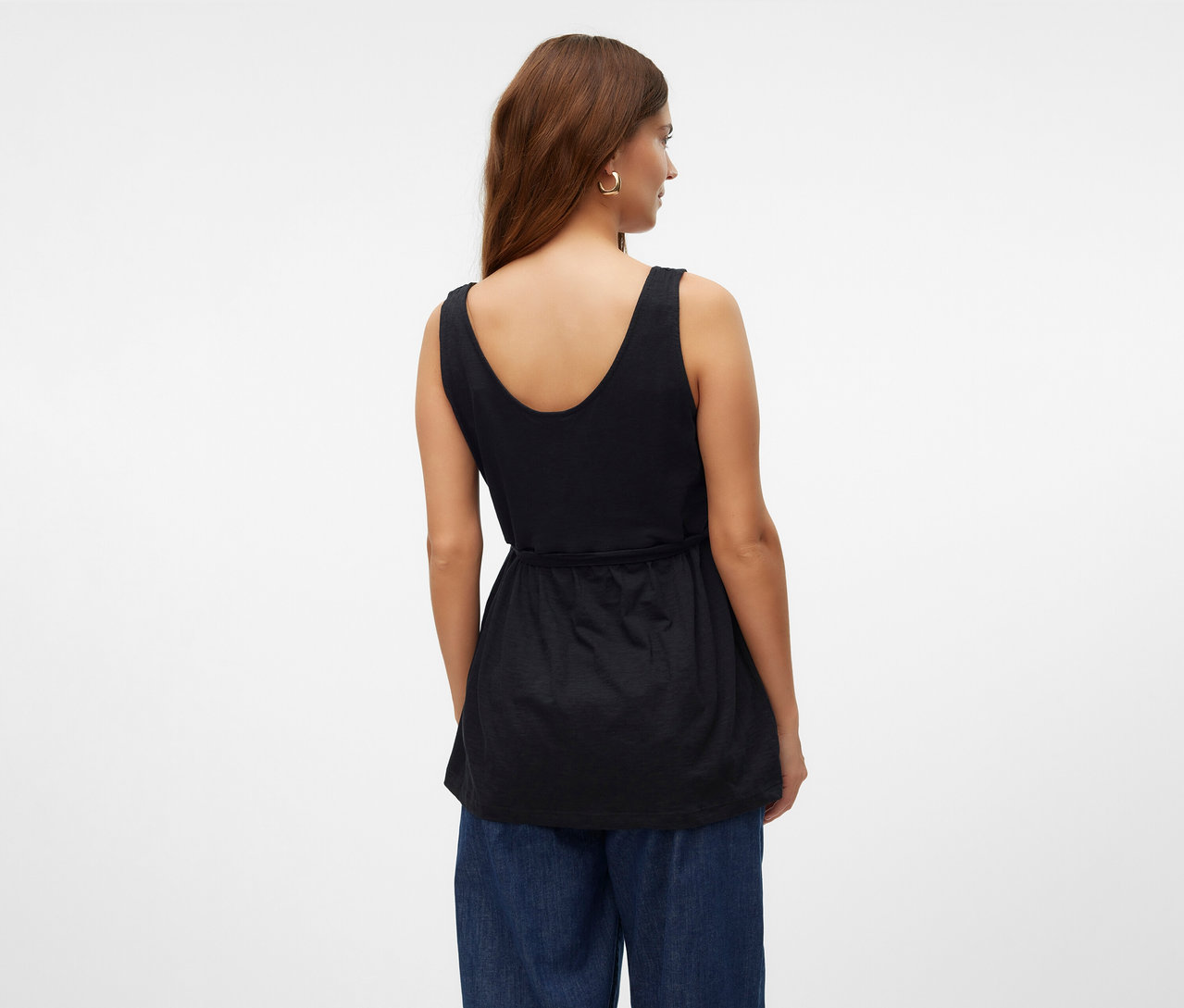 Žena zezadu v kojícím topu MAMALICIOUS »MLEVI LIA« a modrých džínách.