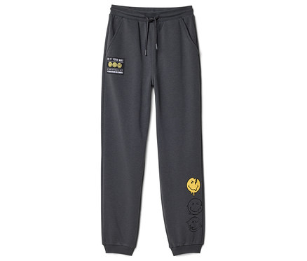 Tmavě šedé dětské joggingové kalhoty SMILEYWORLD® se stahovací šňůrkou, nášivkou "DO IT YOUR WAY" a třemi tajícími smajlíky na pravé nohavici.