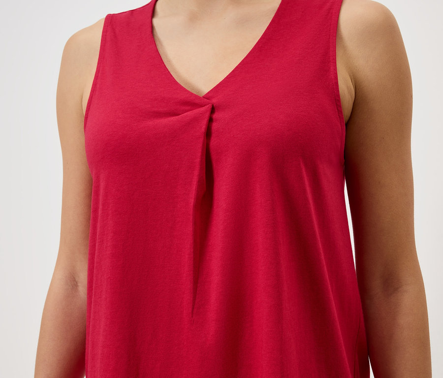 Detail ženy v červeném tílku s výstřihem do V.