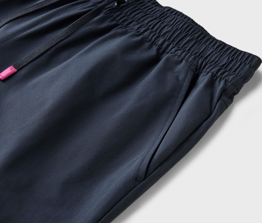 Detailní záběr na tmavě modré kalhoty s elastickým pasem a stahovací šňůrkou