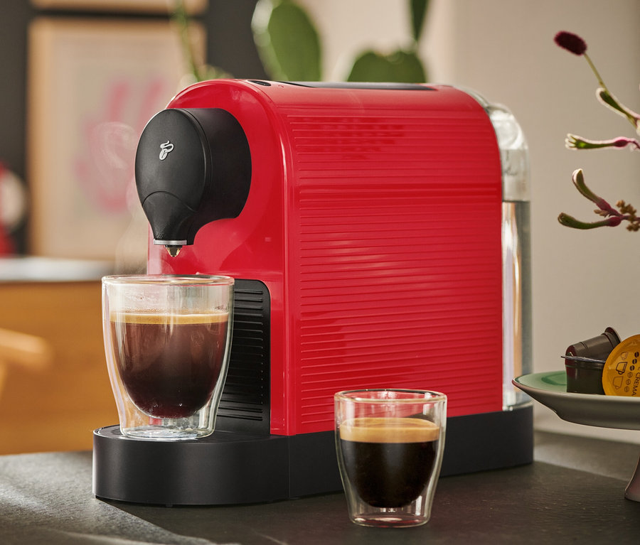 Červený kávovar Cafissimo pure+ s dvěma šálky kávy.