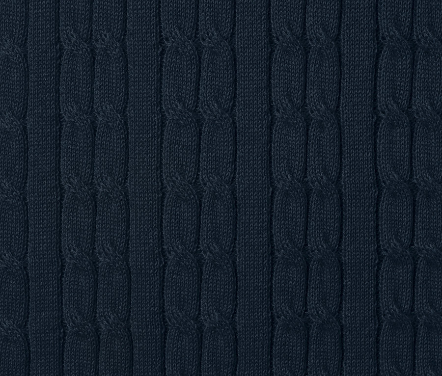 Detail modrého pleteného svetru s copánkovým vzorem.