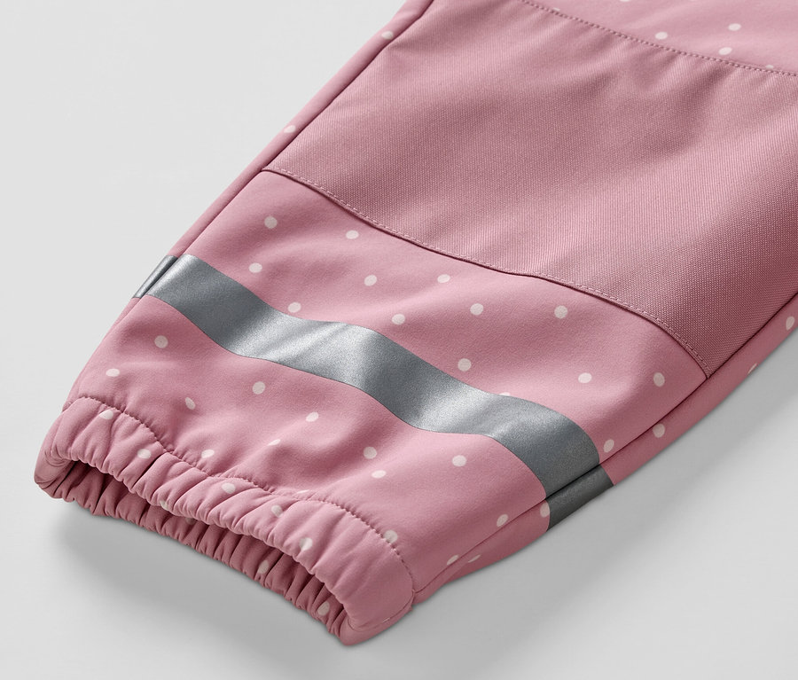 Detail rukávu dětské softshellové kombinézy s bílými puntíky a reflexním pruhem.