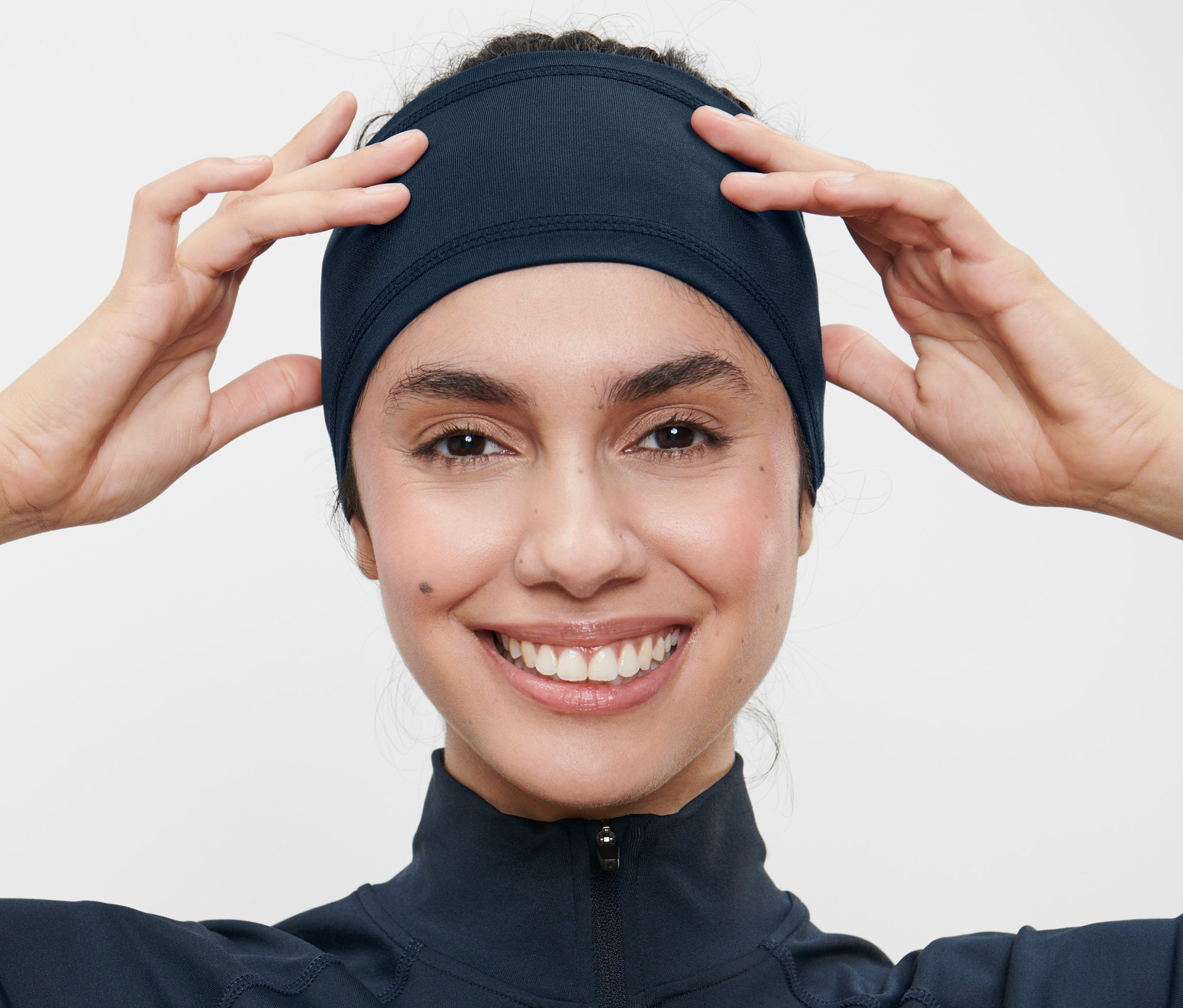 Žena si upravuje sportovní čelenku.