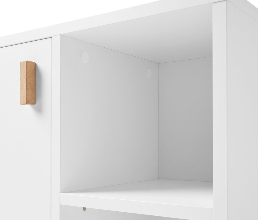 Detail bílé skříňky pod umyvadlo s dvířky a bočním prostorem.