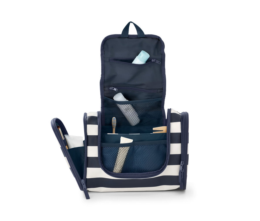 Otevřená toaletní taštička s modrými a bílými pruhy, uvnitř jsou toaletní potřeby.