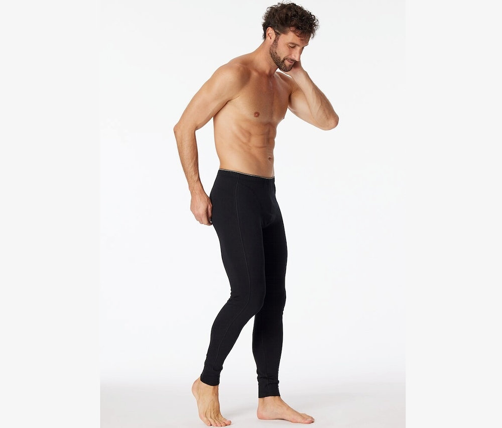 Muž pózuje v dlouhých černých spodkách z biobavlny SCHIESSER.