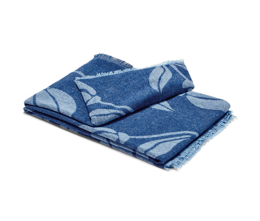 Složená deka s třásněmi s květinovým vzorem v modré barvě.