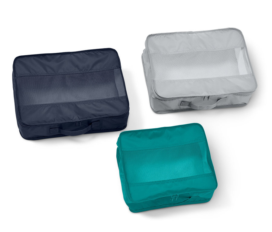 Tři cestovní úložné tašky: tmavě modrá, šedá a tyrkysová.