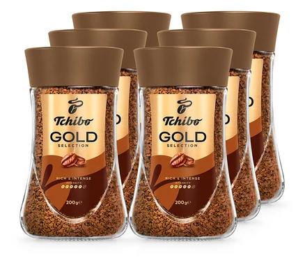 Šest sklenic instantní kávy Tchibo Gold Selection s hnědým víčkem.