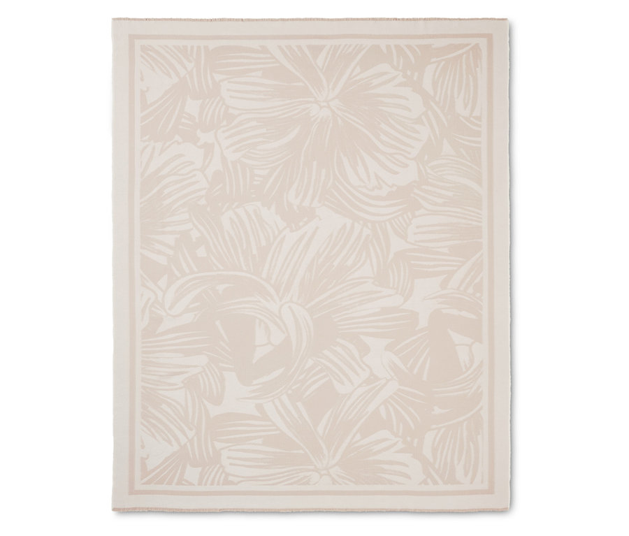 Krémová deka s květinovým vzorem a lemem.