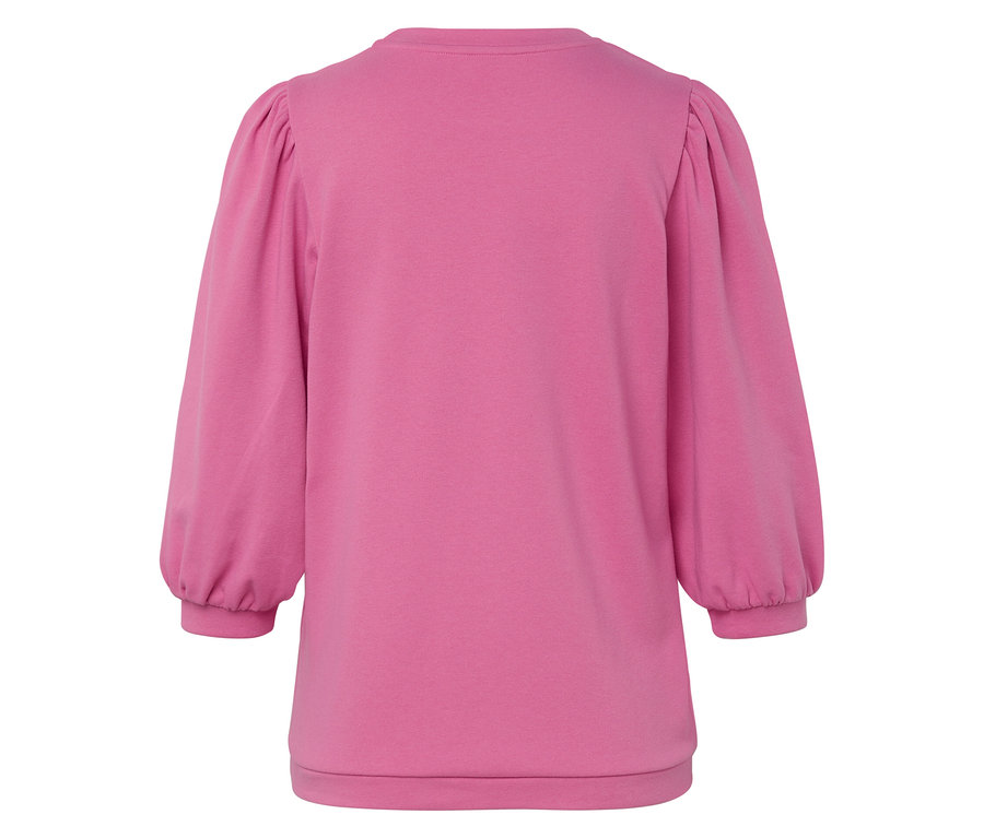 Detail růžové mikiny s balónovými rukávy.
